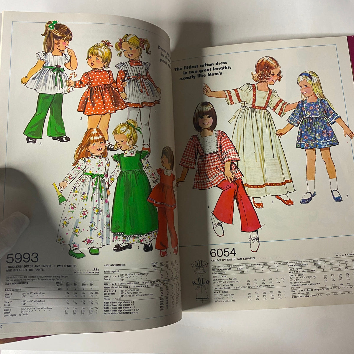 1973 Simplicity Holiday Gift Catalog page illustrating adorable toddler dresses and smocks, offering sewing patterns that replicate stylish looks for children.
