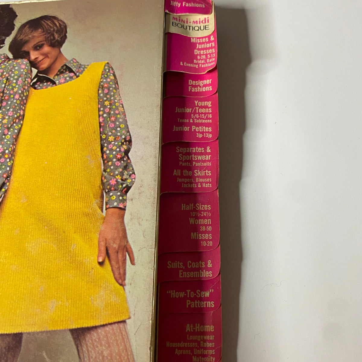 Close-up on the side of the 1968 August Simplicity Catalog displaying sections on mini-midi boutique styles and various fashion categories including juniors and misses.