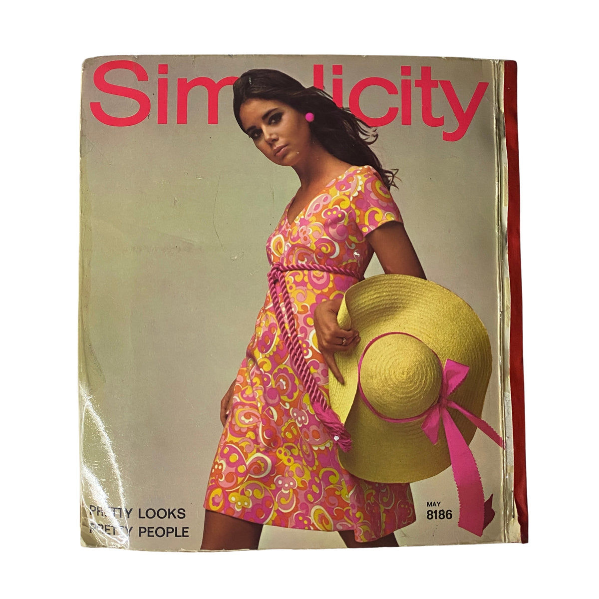 1969 May Simplicity Catalog Sewing Pattern Store Giant Counter Book Fashion cover featuring a model in a colorful pink floral dress with a wide-brimmed straw hat. Ideal for vintage fashion enthusiasts and collectors.