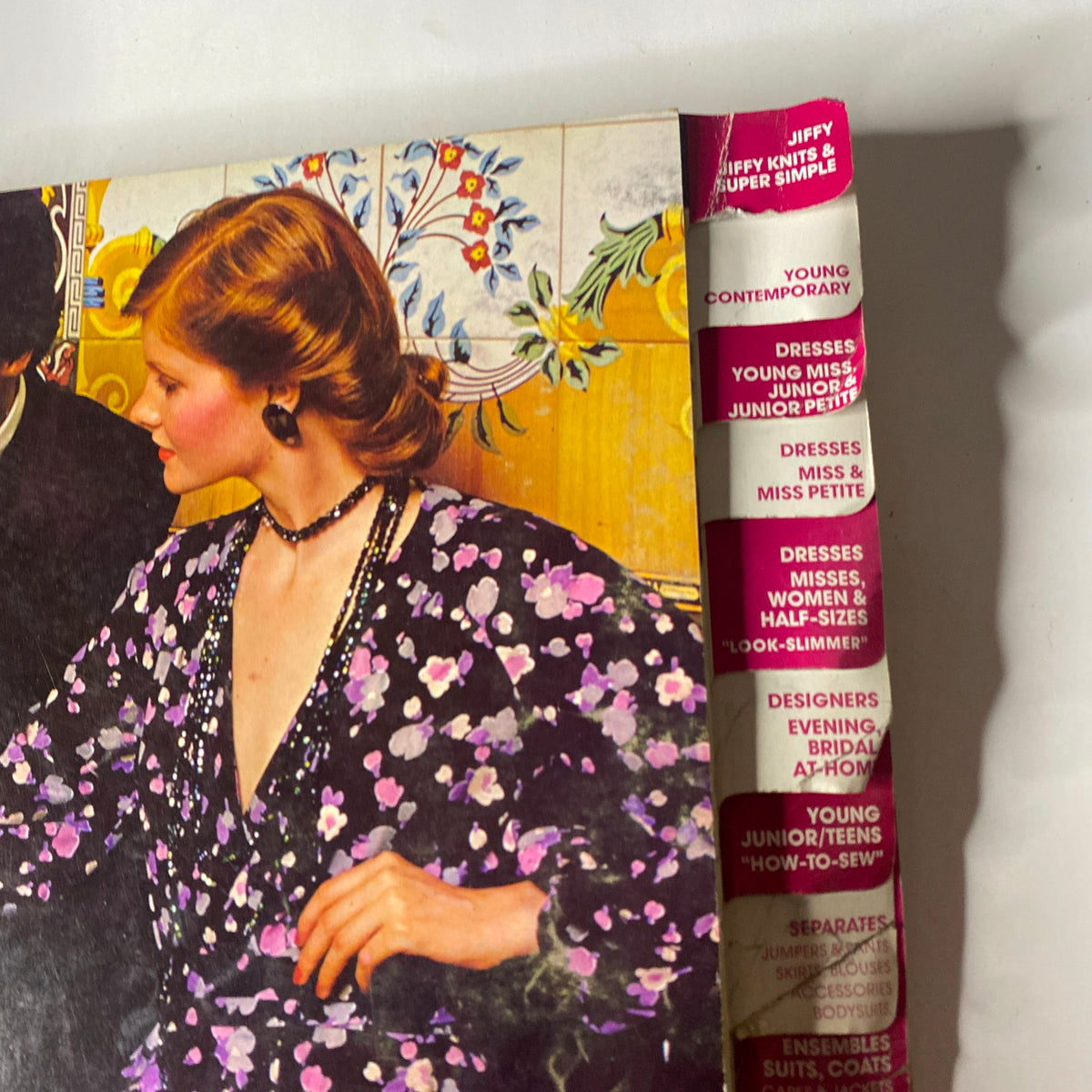 Close-up of a model in the 1973 January Simplicity Catalog, featuring fashionable floral attire and design sections including Young Contemporary and Dresses for different sizes.