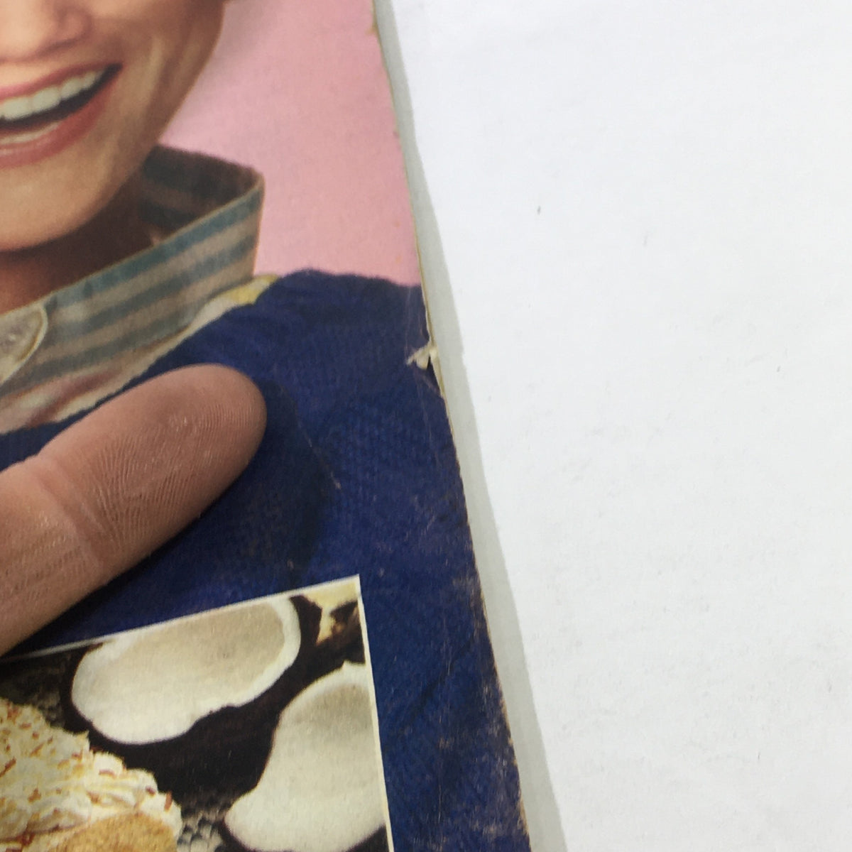 Close-up of a woman's hand holding the cover of VTG Woman's World Magazine: June 3 1986, showcasing a delicious recipe for Piña Colada Roll.