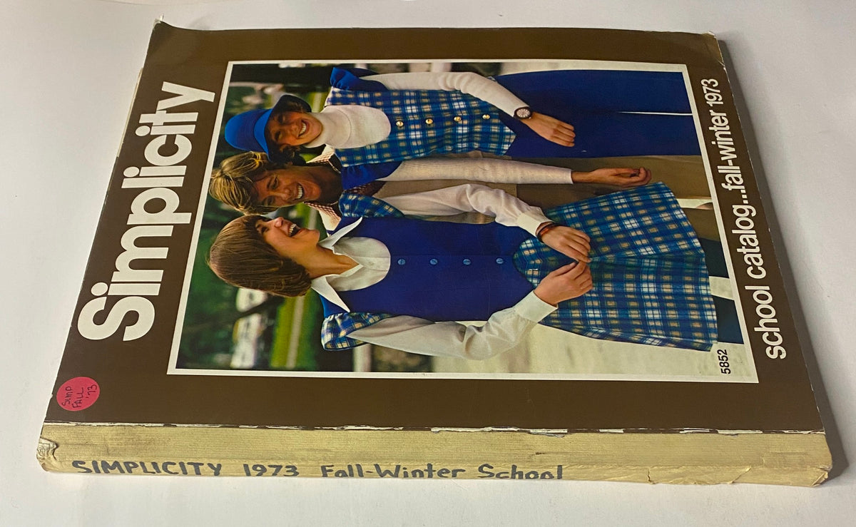 1973 Simplicity Fall and Winter School Catalog featuring models in fashionable outfits, showcasing the cover design of the sewing pattern catalog.