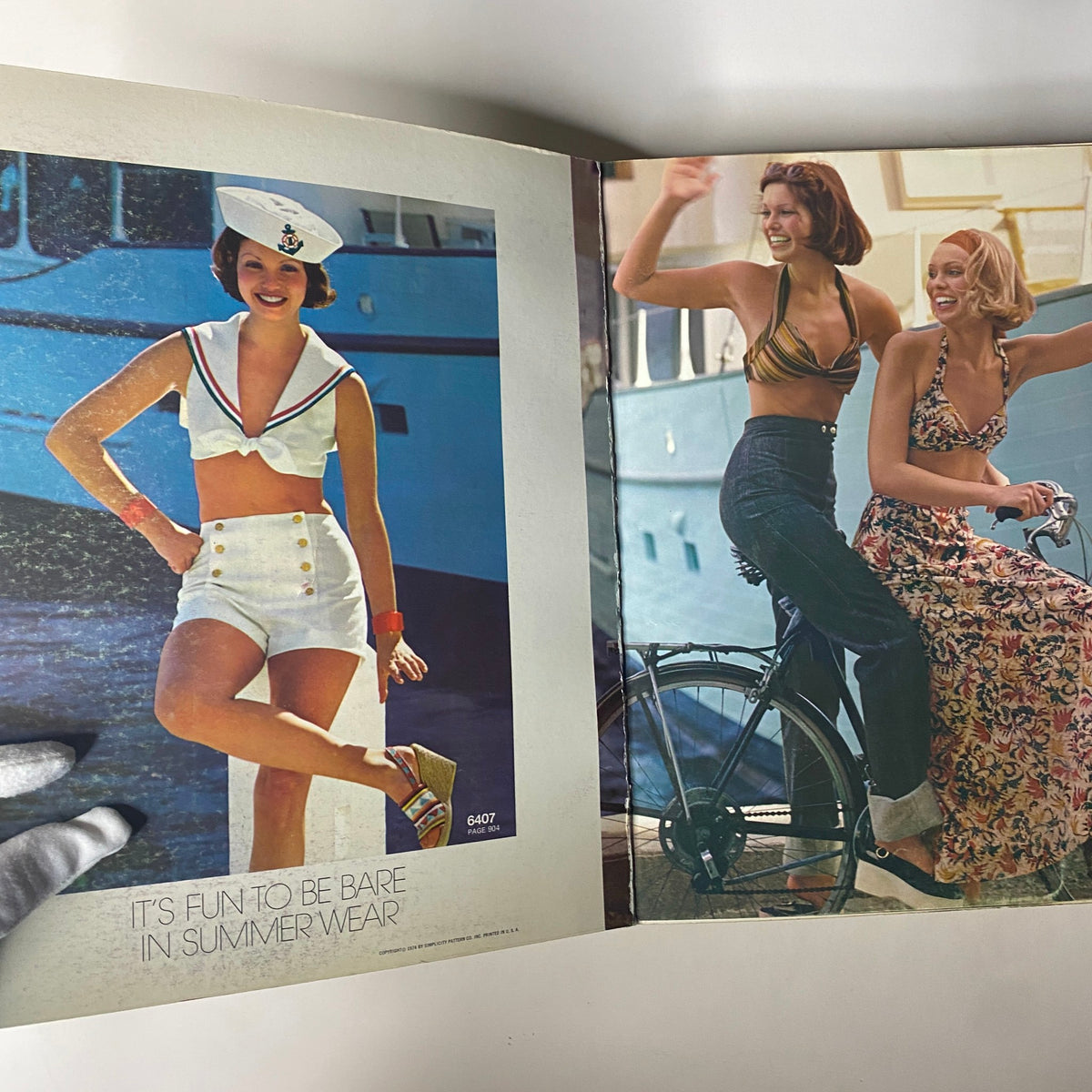 Inside the 1974 July Simplicity Summer Catalog displaying two models in summer outfits near a boat, with an emphasis on summer wear.