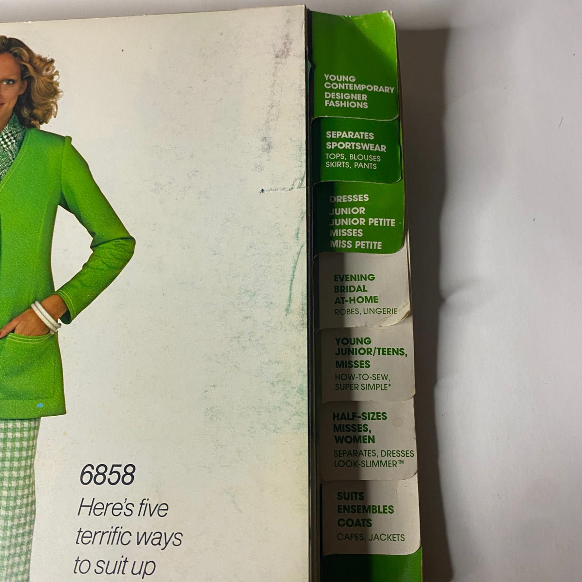 Spine of the 1975 April Simplicity Catalog with distinct categories for contemporary fashion, including evening wear, sportswear, and special patterns, appealing to retro fashion enthusiasts.