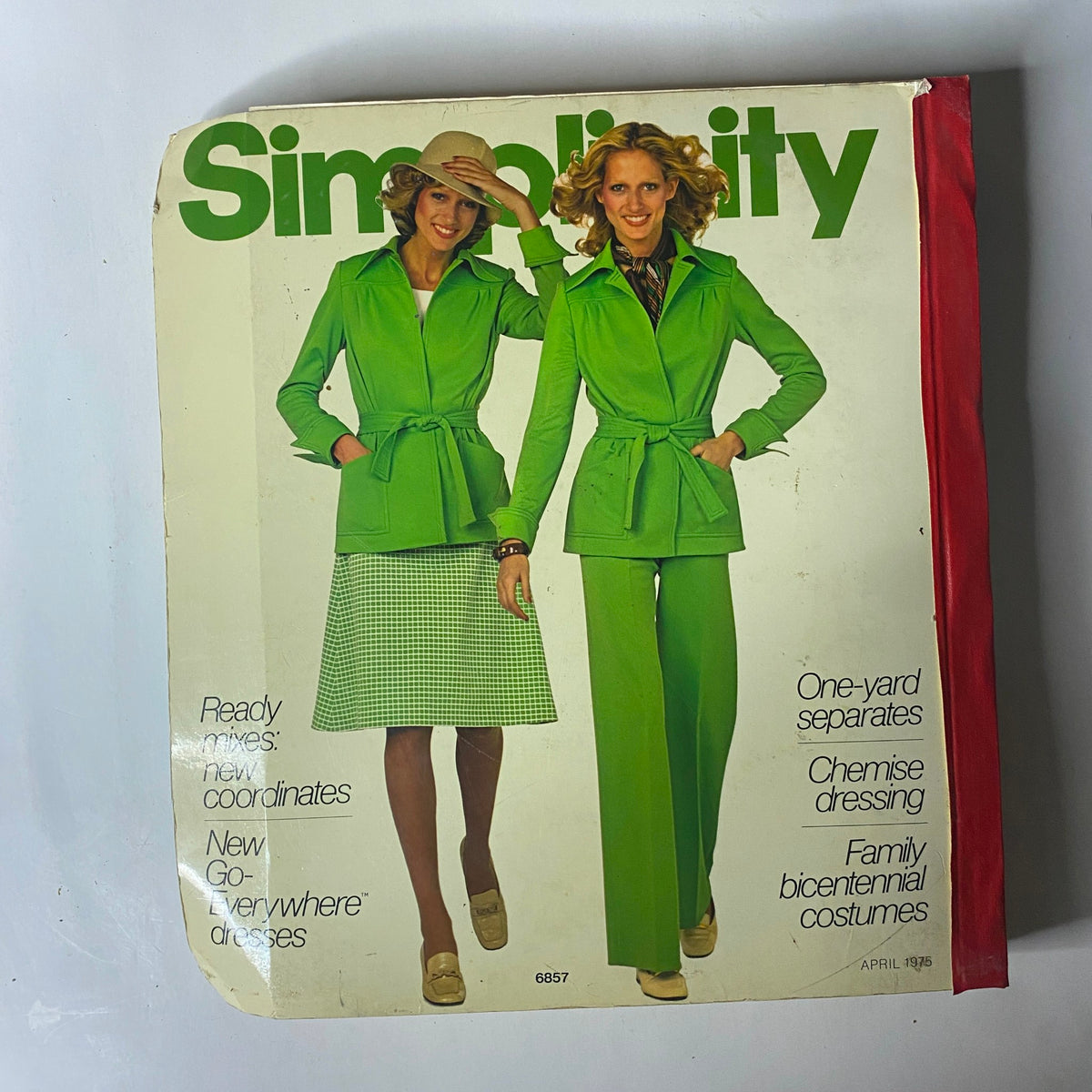 Front cover of the 1975 April Simplicity Catalog featuring two models in green outfits, emphasizing stylish one-yard separates and coordinating fashion.