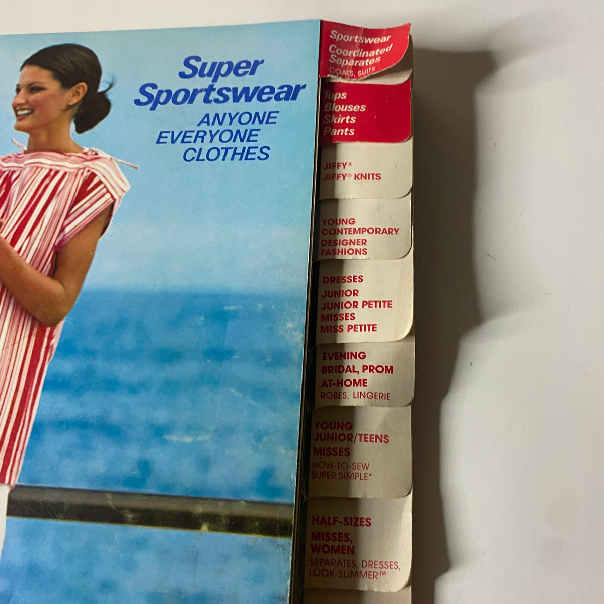 Close-up of the 1976 June Simplicity Catalog showing the tabbed sections including 'Super Sportswear,' highlighting various categories of sewing patterns.