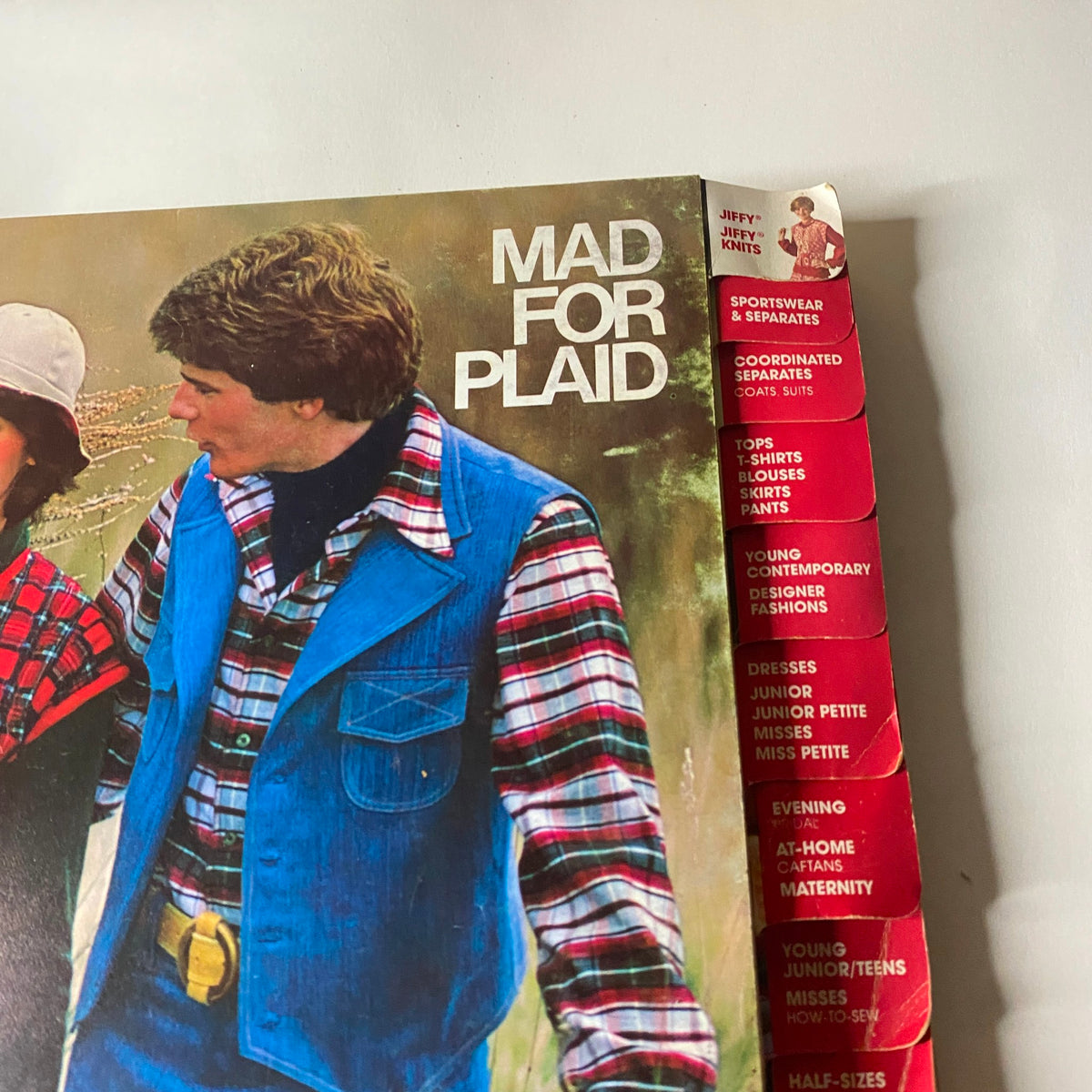 Close-up image of the 1976 October Simplicity Sewing Pattern Catalog displaying the title 'Mad for Plaid' along with detailed tabs for various sewing categories.