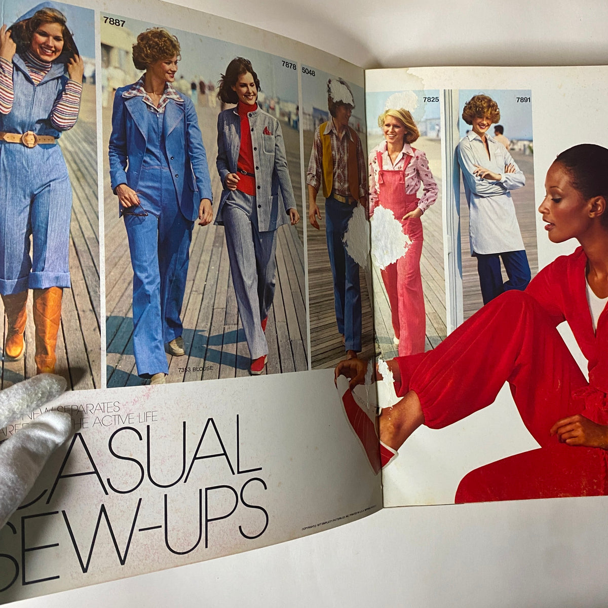 Interior page of the 1977 March Simplicity Sewing Pattern Catalog showcasing casual sew-ups, featuring multiple styles and colorful outfits on models.