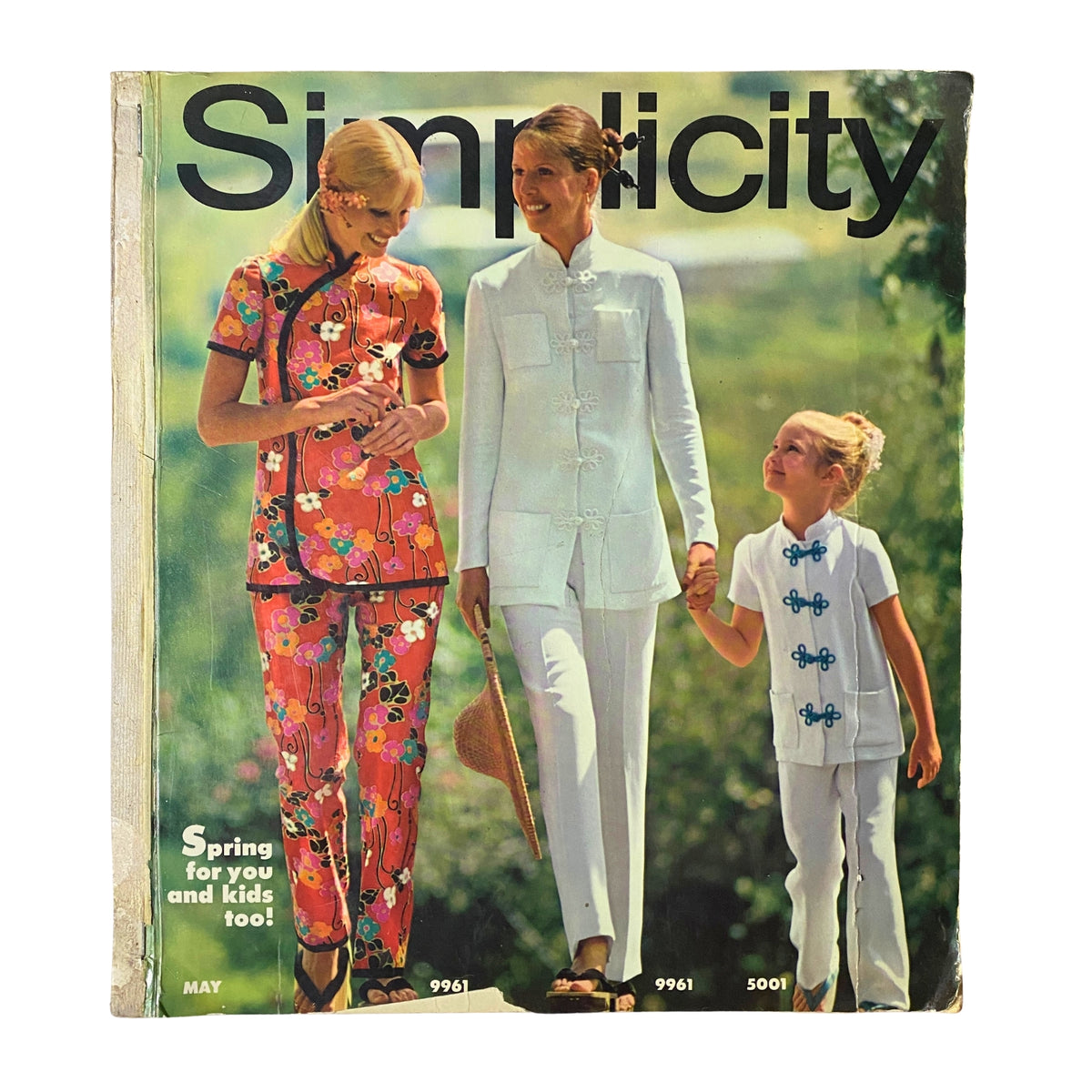 Cover of the 1970s May Simplicity Sewing Pattern Catalog featuring stylish floral patterns, showcasing women and children in colorful spring outfits, highlighting the collection's elegance and timeless charm.