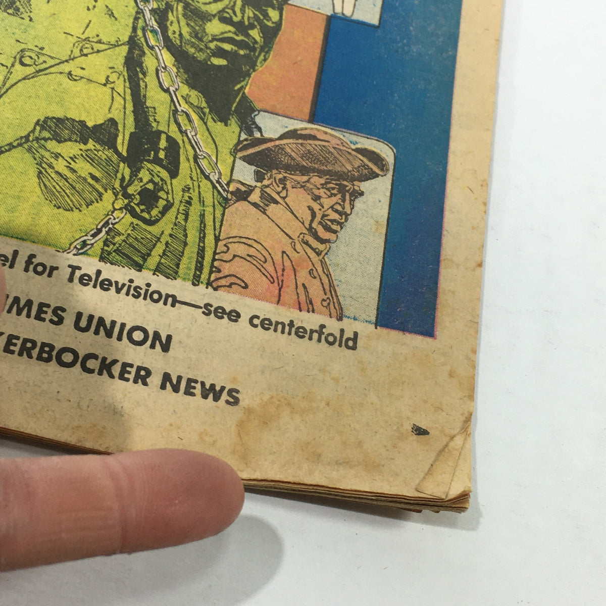 Detail of the bottom corner of the VTG TV Dial Complete Cable Listings January 15-22 1977 'Roots' ABC Novel front cover highlighting its vintage features and minor creases.