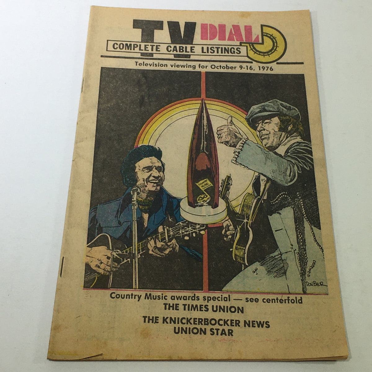 VTG TV Dial Complete Cable Listings October 9-16 1976 showcasing a colorful cover illustration featuring two country music artists performing, signifying the Country Music Awards.