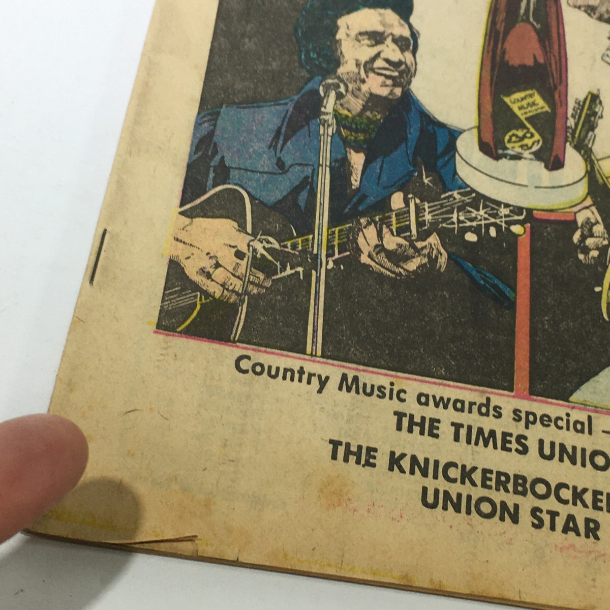 Close-up of VTG TV Dial Complete Cable Listings October 9-16 1976 highlighting the details of the cover illustration with a focus on the guitar and microphone, reflecting the era of country music.