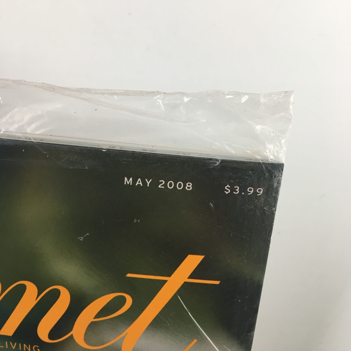Close-up of the top edge of Gourmet Magazine May 2008, featuring the month and price in sealed condition. Ideal for vintage magazine collectors.
