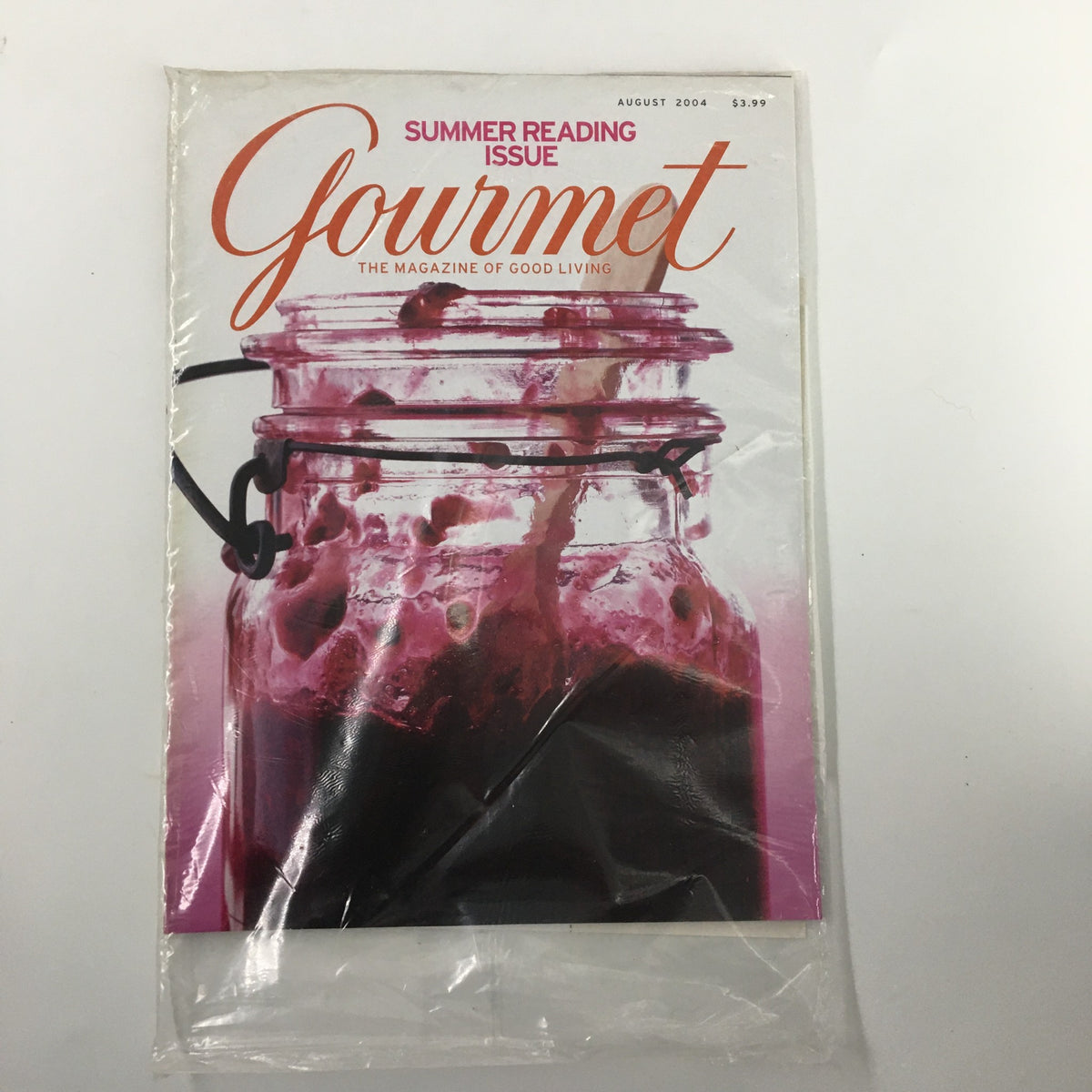 Gourmet Magazine August 2004 Black Berry Jam Summer Reading Issue cover featuring a beautiful jar of jam, symbolizing summer culinary adventures. The magazine is sealed and showcases vibrant colors.
