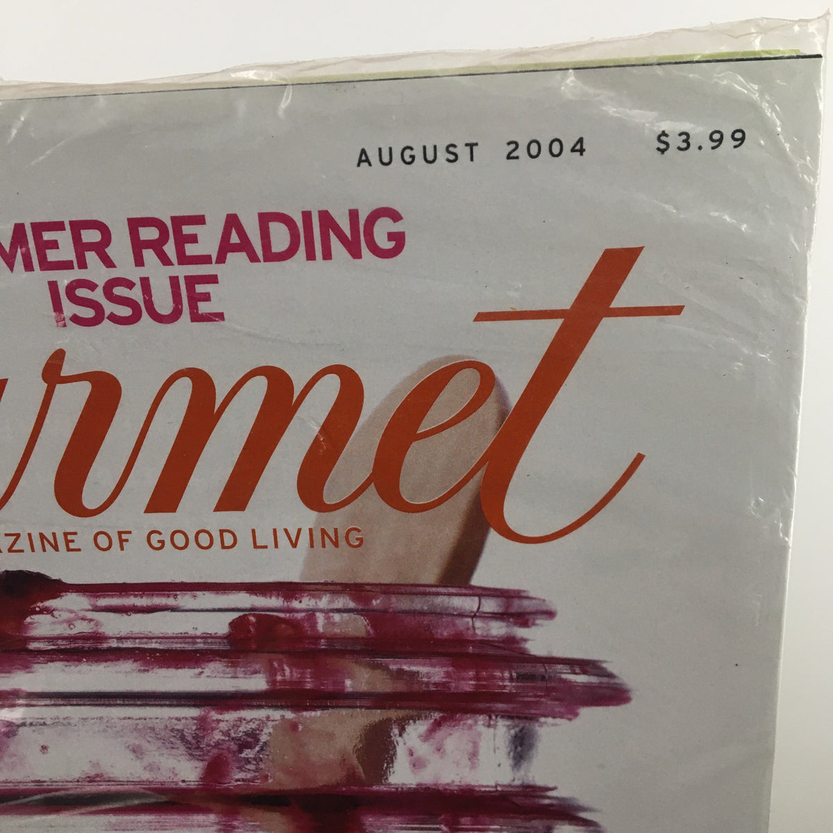 Close up of the Gourmet Magazine August 2004 Black Berry Jam Summer Reading Issue title with a price tag, highlighting its value as a collectible item and showcasing nostalgic culinary themes.