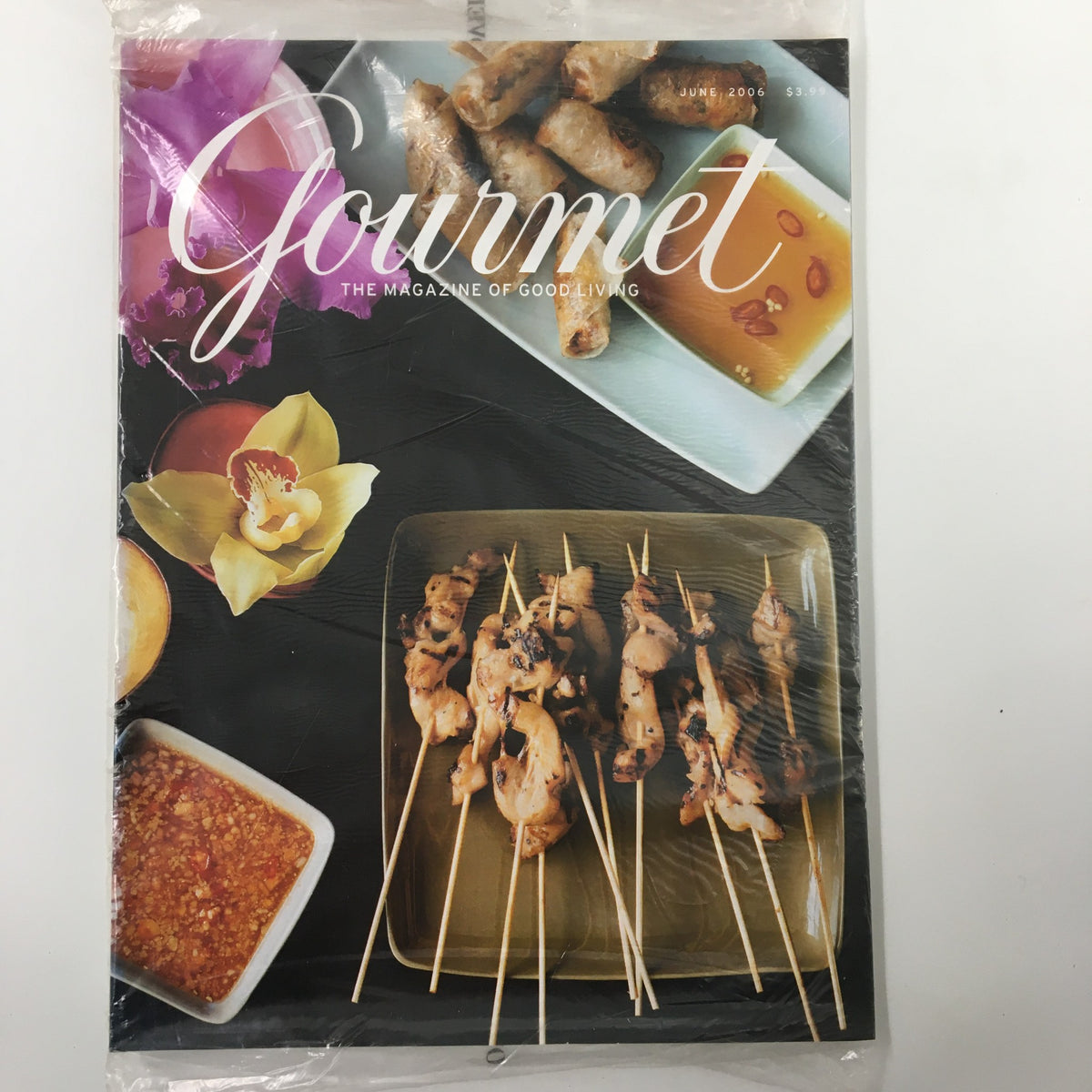 Gourmet Magazine June 2006 cover featuring delicious skewered dishes, alongside a vibrant orchid, embodying the essence of gourmet cooking.