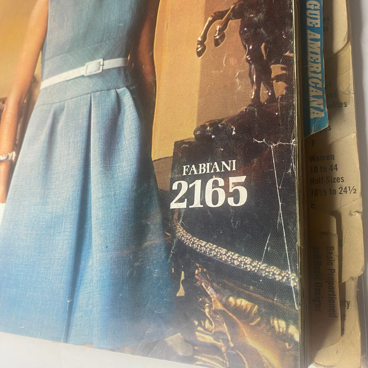 Cover of the 1969 Vogue Patterns July Catalog featuring a vintage fashion illustration of a woman in a blue dress, showcasing sophisticated style, with the text 'FABIANI 2165' prominently displayed.