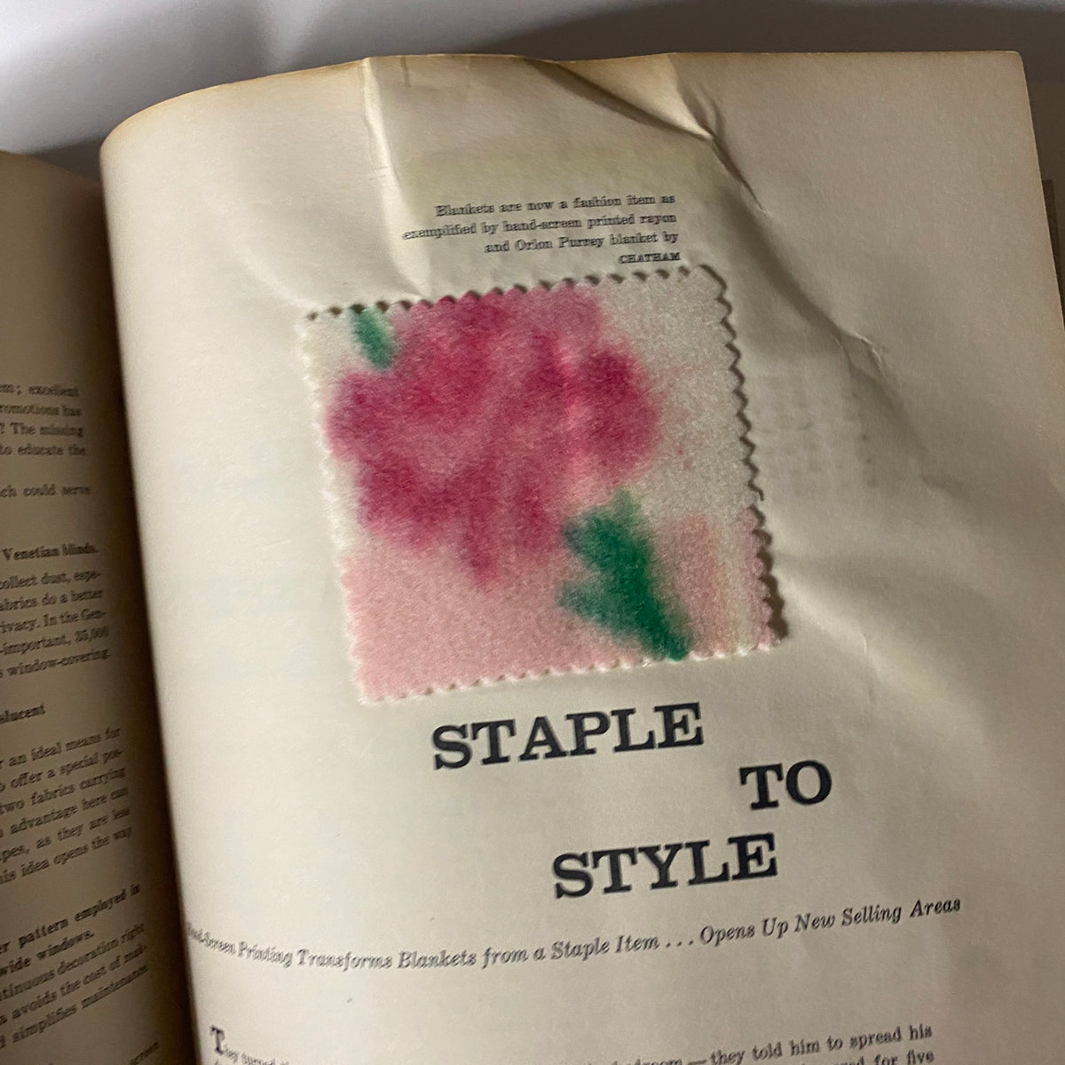 Illustration from the 1957 American Fabrics Spring Catalog showing a floral textile sample with the title 'Staple to Style' discussing the transformation of blankets into fashionable items.