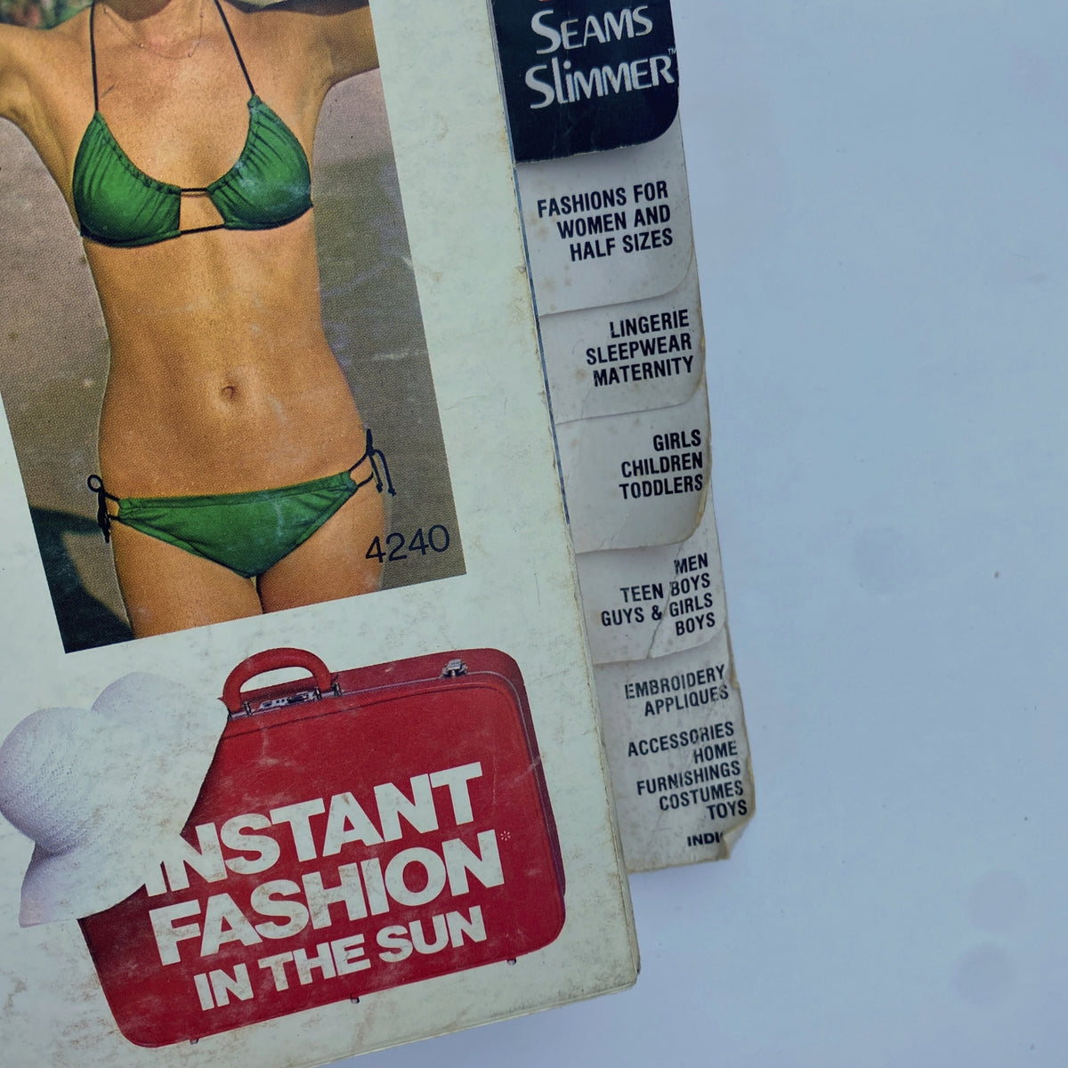 Detailed view of the 1975 July Butterick Catalog featuring beachwear designs, highlighting the Seams Slimmer collection and swimwear options.