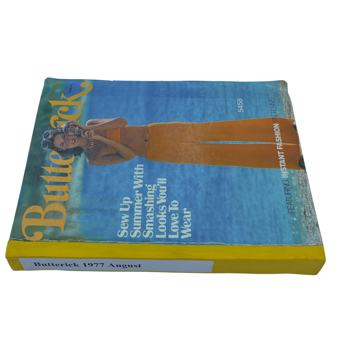 Cover of the 1977 August Butterick Catalog showcasing vibrant summer fashion patterns including swimwear, featuring a model in an orange bikini.