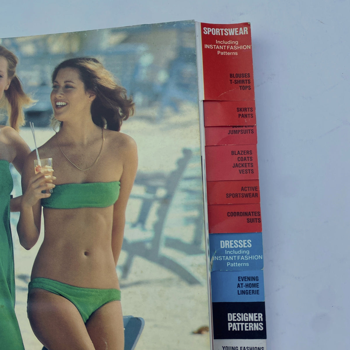 Side view of the 1977 August Butterick Catalog highlighting sportswear patterns with models wearing swimsuits, showcasing a variety of styles for summer.