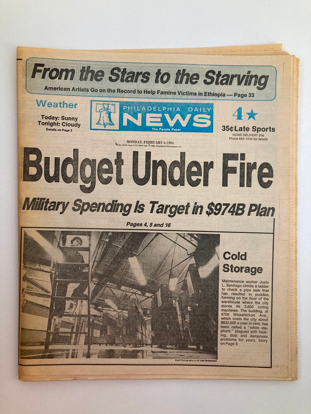 Philadelphia Daily News Tabloid from February 4, 1985 featuring the headline 'Budget Under Fire' with a focus on military spending and a section titled 'Cold Storage' related to Justo L. Santiago.