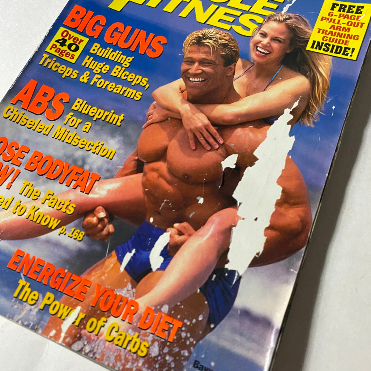 Cover of Muscle & Fitness Magazine, September 1998, featuring Gunter Schlierkamp and Brooke Burns. The cover highlights fitness topics like building biceps, blueprint for abs, and tips on diet, showcasing a vibrant image of Gunter with Brooke in a playful pose on the beach.