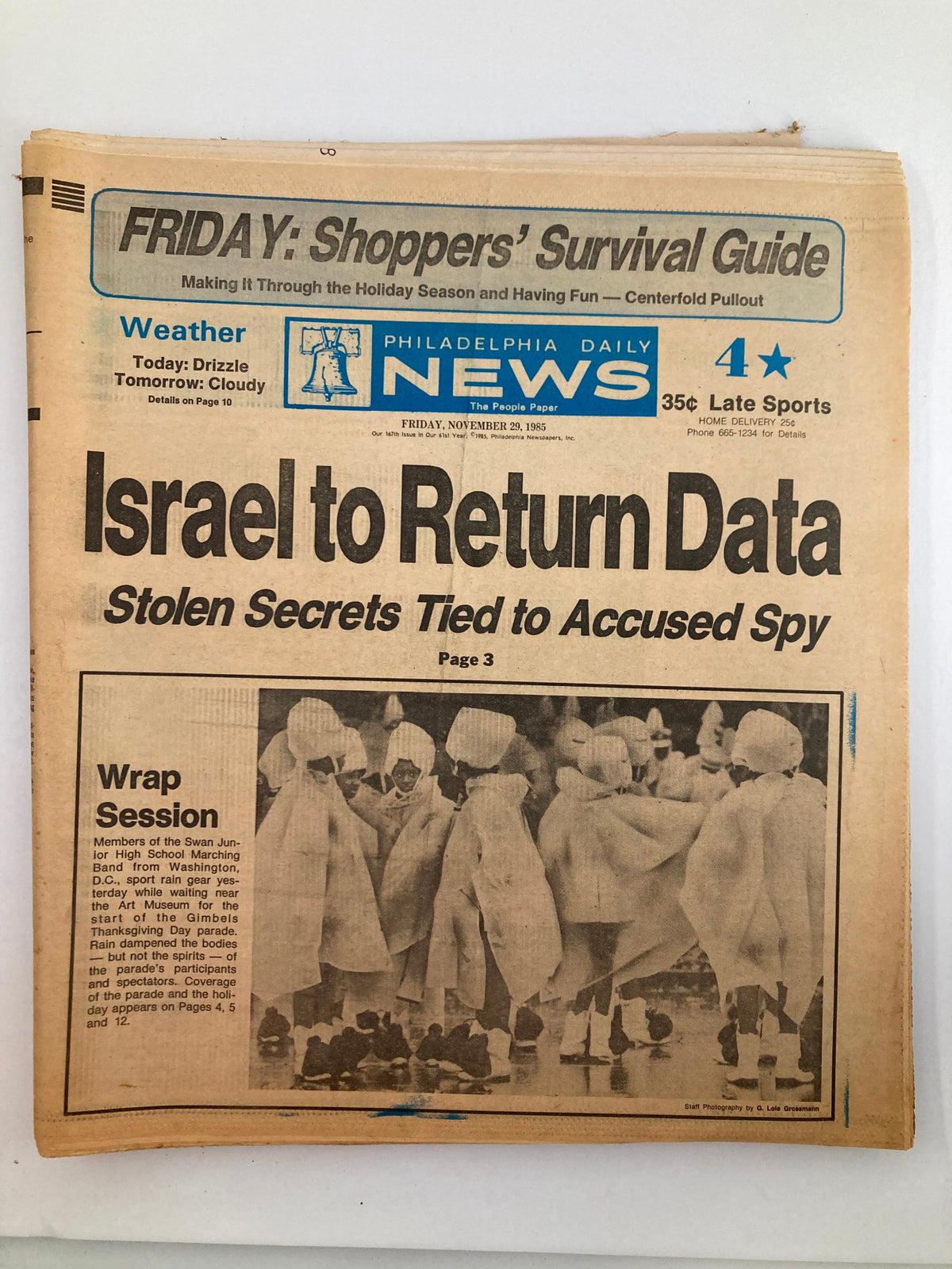 Philadelphia Daily News tabloid from November 29, 1985, featuring the Swan Junior High School Marching Band. The front page highlights the band's performance and includes a news article about their participation in the Gimbels Thanksgiving Day parade. A significant historical reference showcasing school spirit and local community involvement.