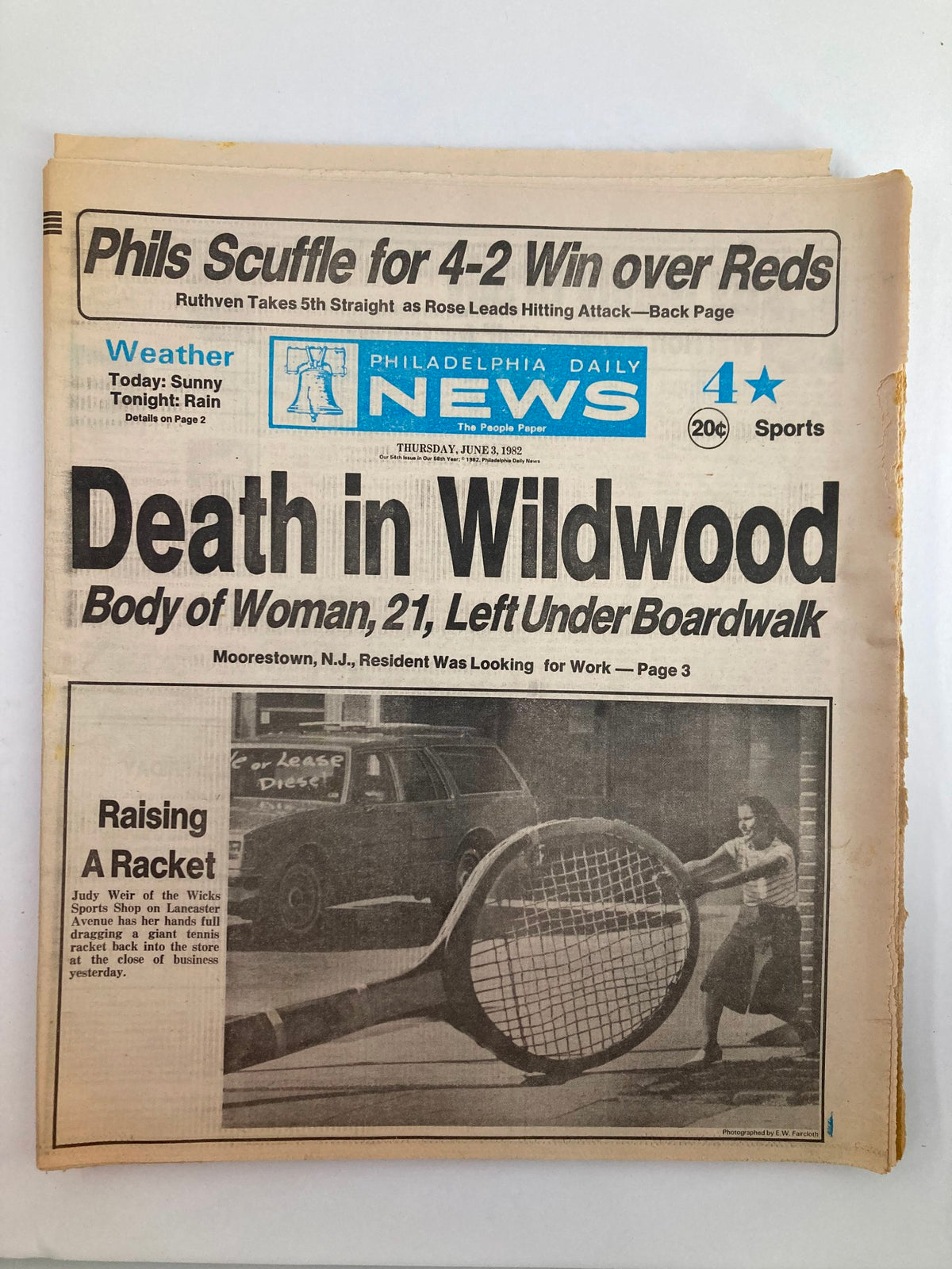 Philadelphia Daily News Tabloid from June 3, 1982, featuring the headline 'Death in Wildwood' and the article 'Raising A Racket' with a photo depicting a woman playing tennis alongside news about a body found under a boardwalk.