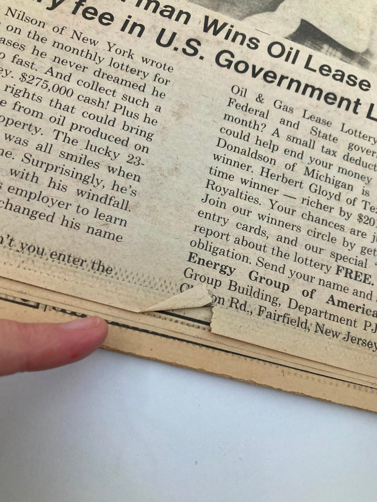 Close-up image of an article from the Philadelphia Journal Tabloid dated August 28, 1981, detailing a lottery winner's story, showing a torn edge on the newspaper.