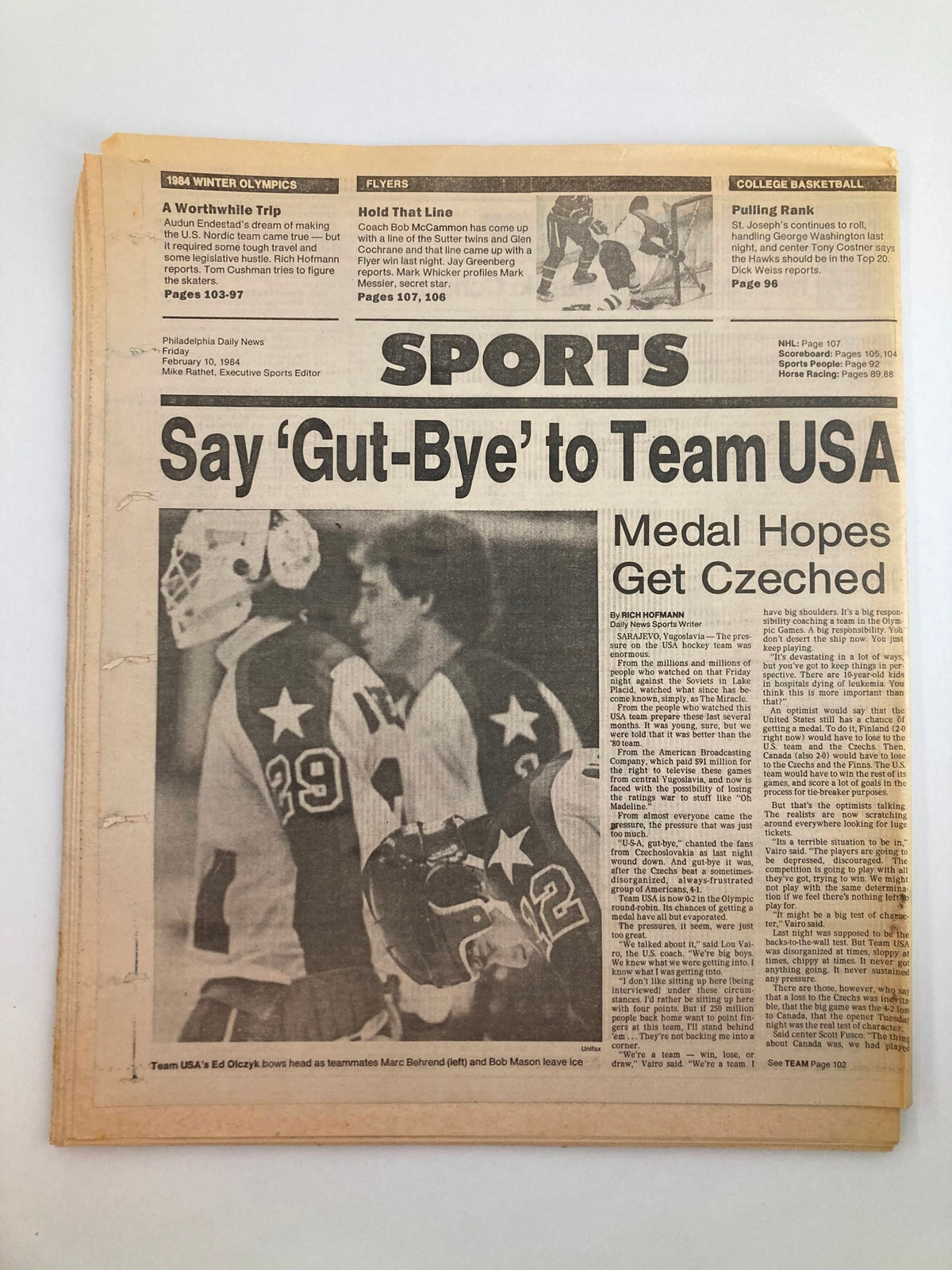 Sports section of the Philadelphia Daily News Tabloid from February 10, 1984, titled 'Say Gut-Bye to Team USA'. It highlights medal hopes for Team USA during the Winter Olympics, featuring action shots of hockey players. This historical tabloid, authored by Mark Haroldsen, reflects the sporting culture of the early 1980s.