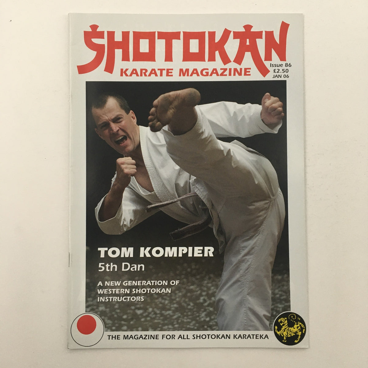 Cover of Shotokan Karate Magazine January 2006 Issue 86 featuring Sensei Tom Kompier, 5th Dan, showcasing a high karate kick. This collectible magazine highlights insights on Shotokan karate techniques.