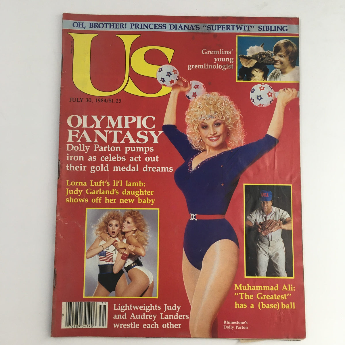 Cover of US Magazine from July 30, 1984 featuring Dolly Parton in a blue outfit with colorful weights, alongside Judy and Audrey Landers in swimsuits, highlighting Olympic Fantasy theme.