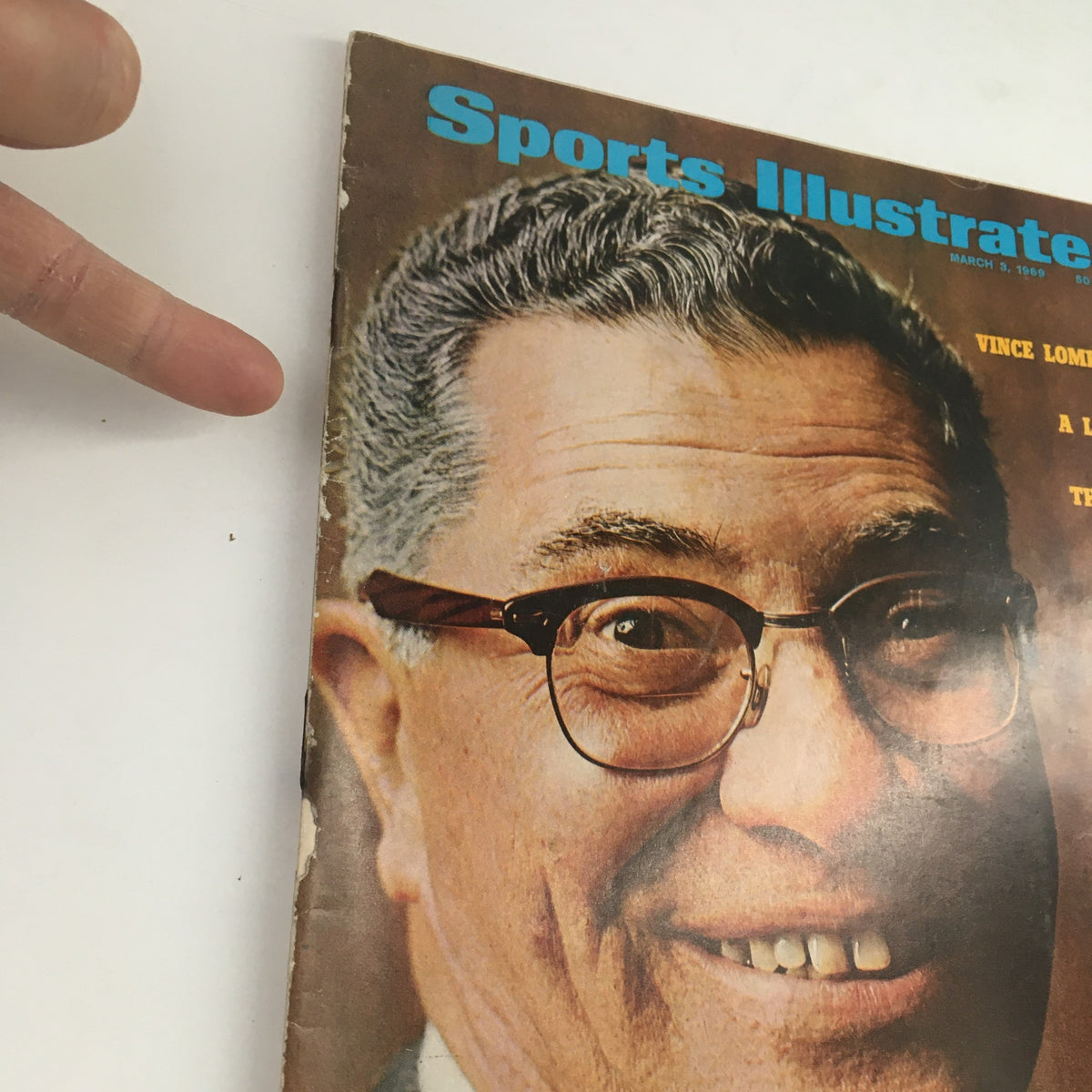 Close-up of Sports Illustrated Magazine March 3 1969 cover with a finger pointing at Vince Lombardi's face, highlighting his expressive features and the magazine's title.