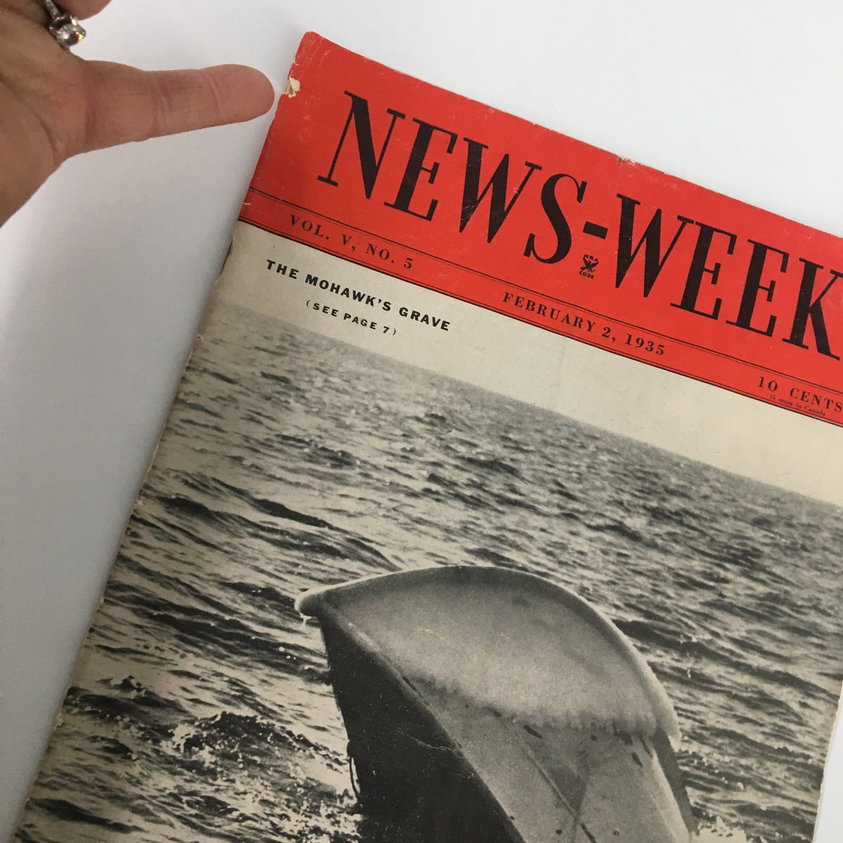 Close-up view of the VTG News-Week Magazine February 2 1935 Vol. V No. 5 cover, highlighting the title 'The Mohawk's Grave' with a hand pointing at the magazine, emphasizing its vintage appeal.