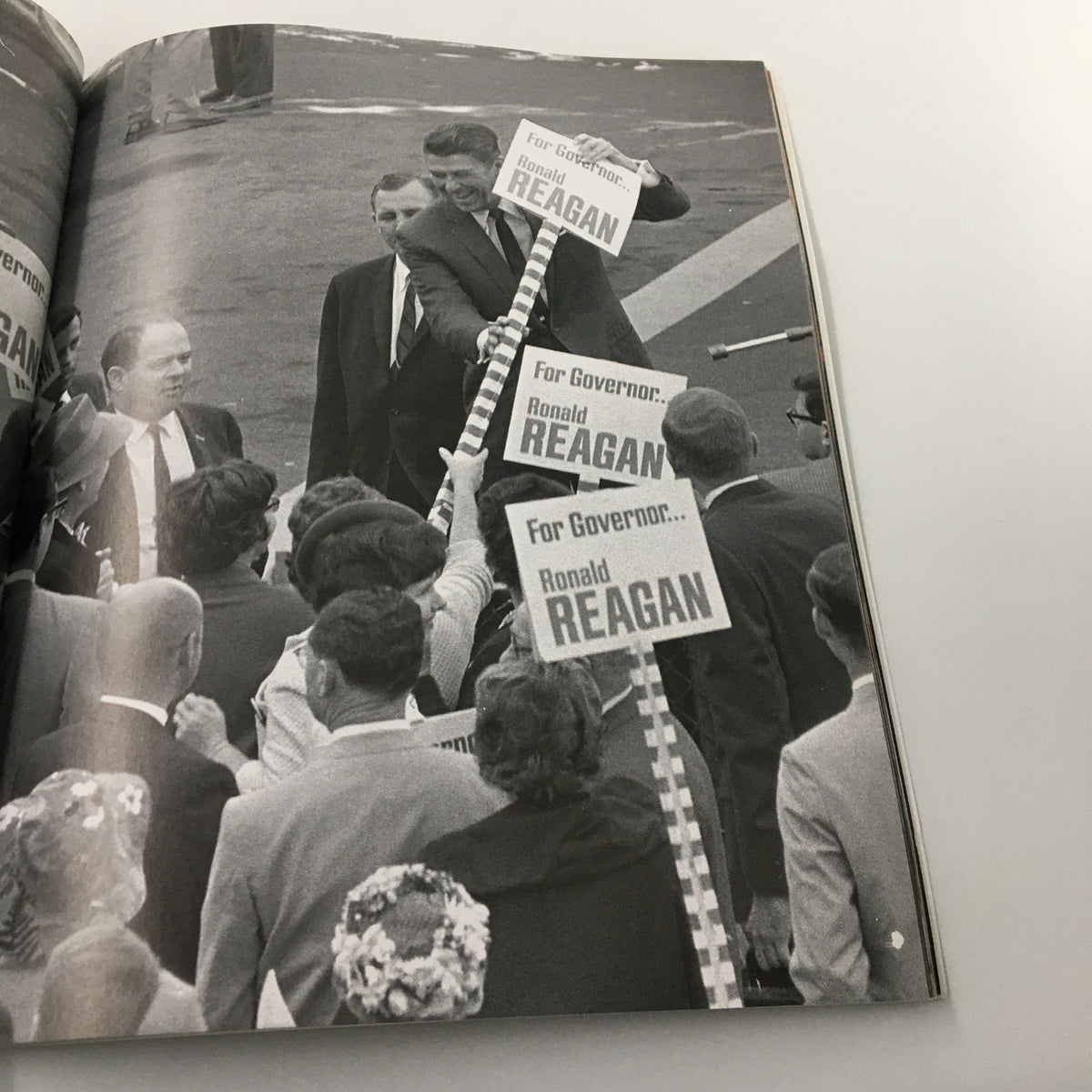 A Tribute To Reagan 1911 - 2004 showcasing supporters holding signs for Ronald Reagan during his governor campaign, highlighting his early political journey.