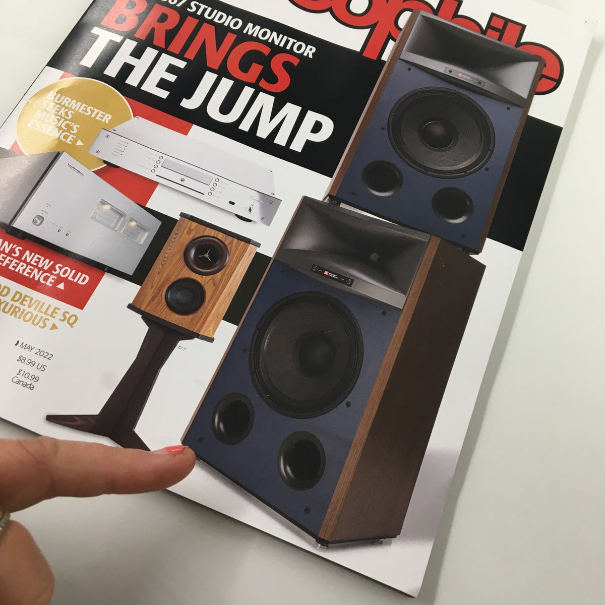 Close-up of Stereophile Magazine May 2022 highlighting loudspeakers and the article 'Paradox Phone 70 Signature Phono Preamp No Label', with a hand pointing to the content.