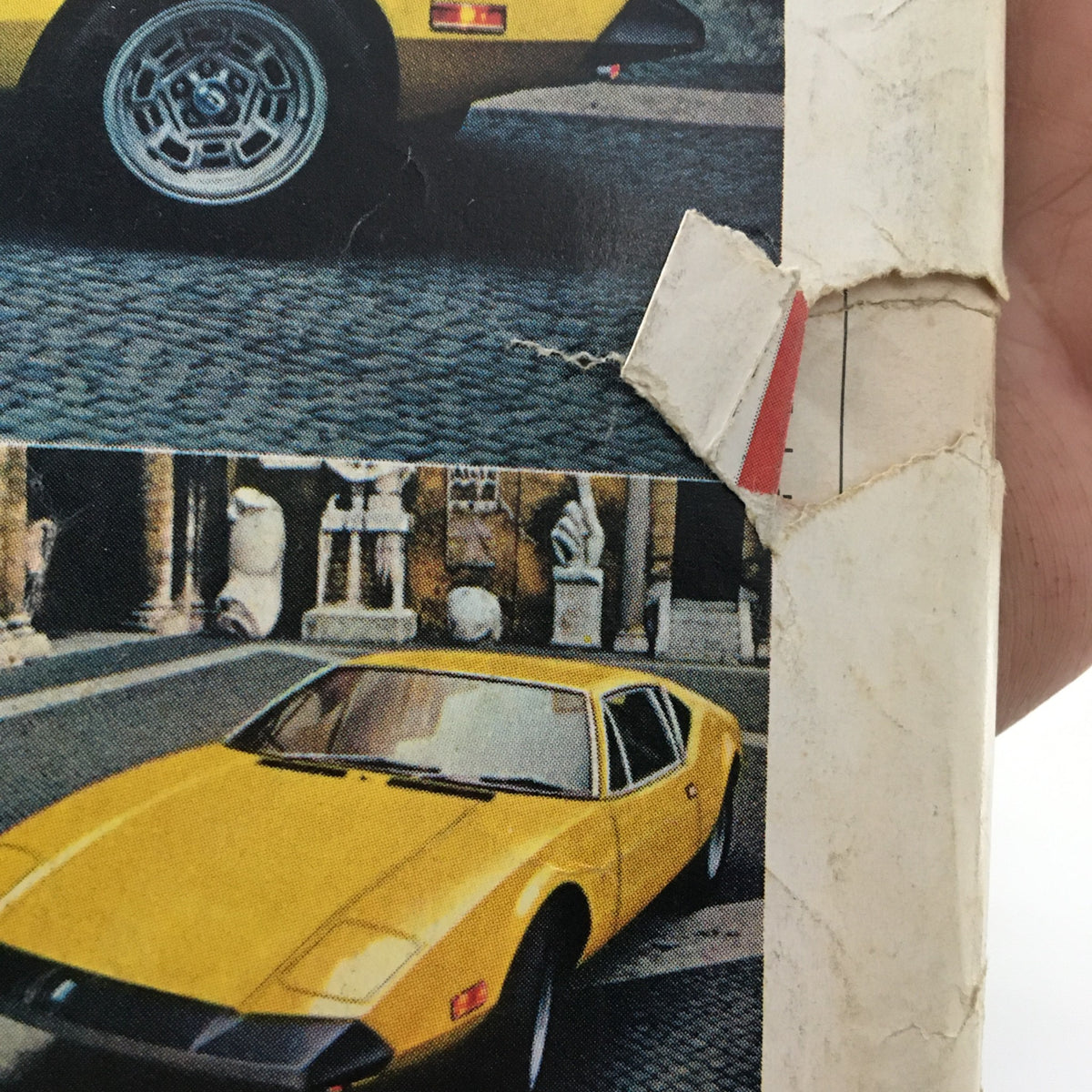 Close-up view of a damaged binding on the VTG Car and Driver December 1973 Wankel-Powered Corvette magazine, displaying wear and tear indicative of its vintage.