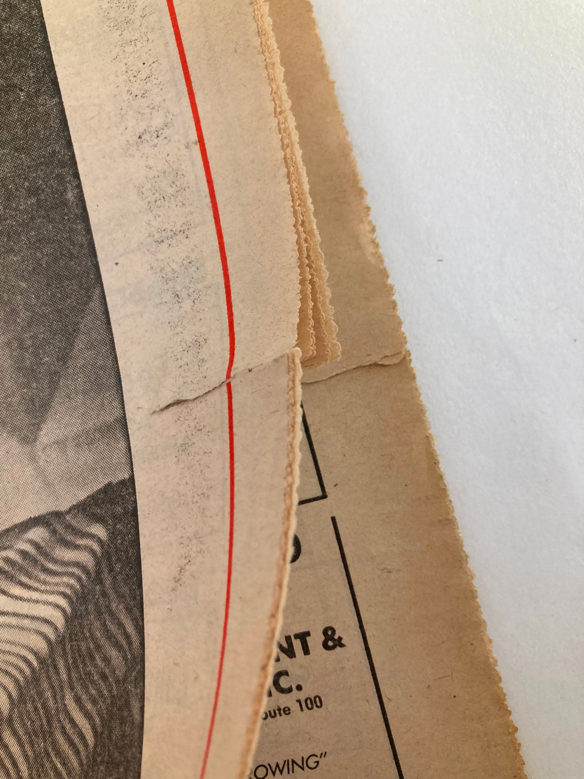 Close-up of the edge of The Mercury Supplementary Tabloid, revealing minor tears and wear, showcasing the vintage condition of the publication from January 5, 1987, titled 'Chronology '86'.
