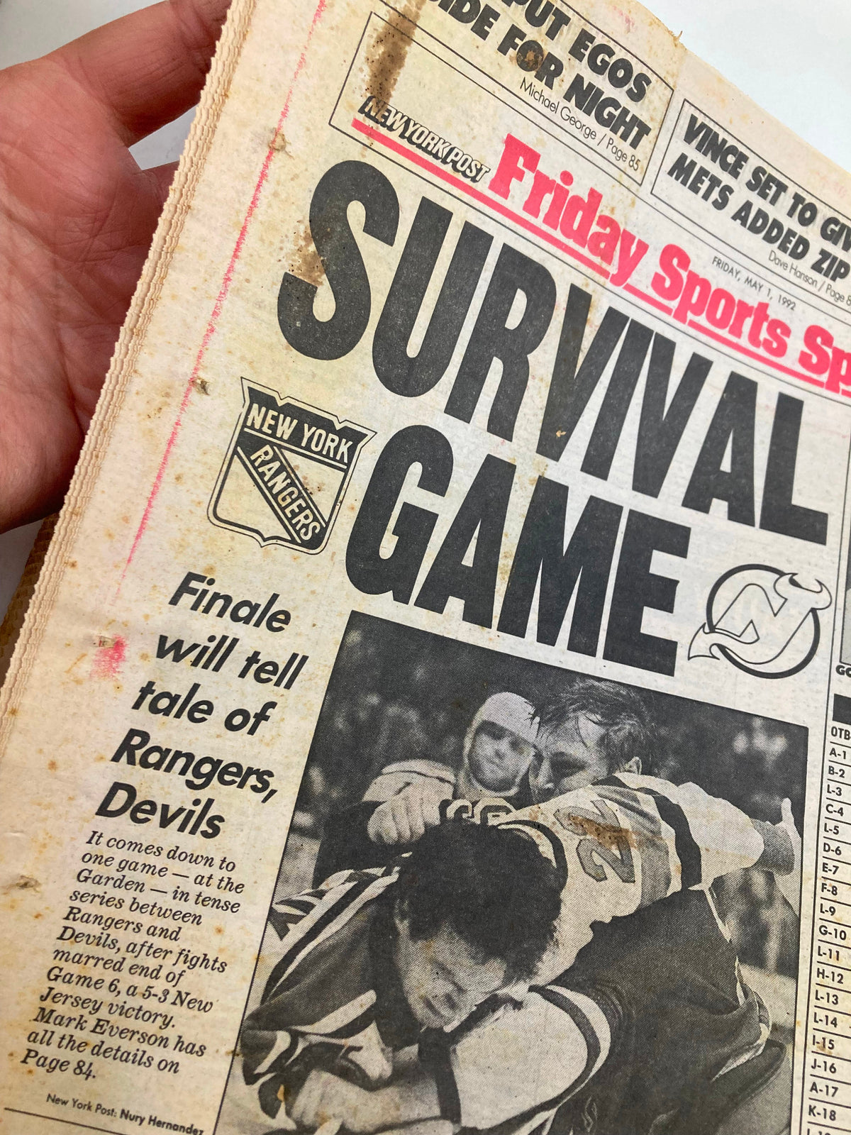 Close-up of the front page of the New York Post Tabloid Metro Edition from May 1, 1992, showcasing the headline 'SURVIVAL GAME' and images related to the New York Rangers vs. New Jersey Devils playoff series.