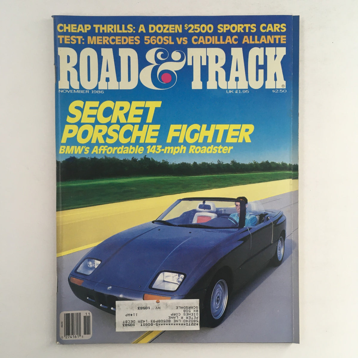 Cover of Road & Track Magazine November 1986 featuring a test comparison of the Mercedes 560SL vs. Cadillac Allante, highlighting automotive performance and luxury.