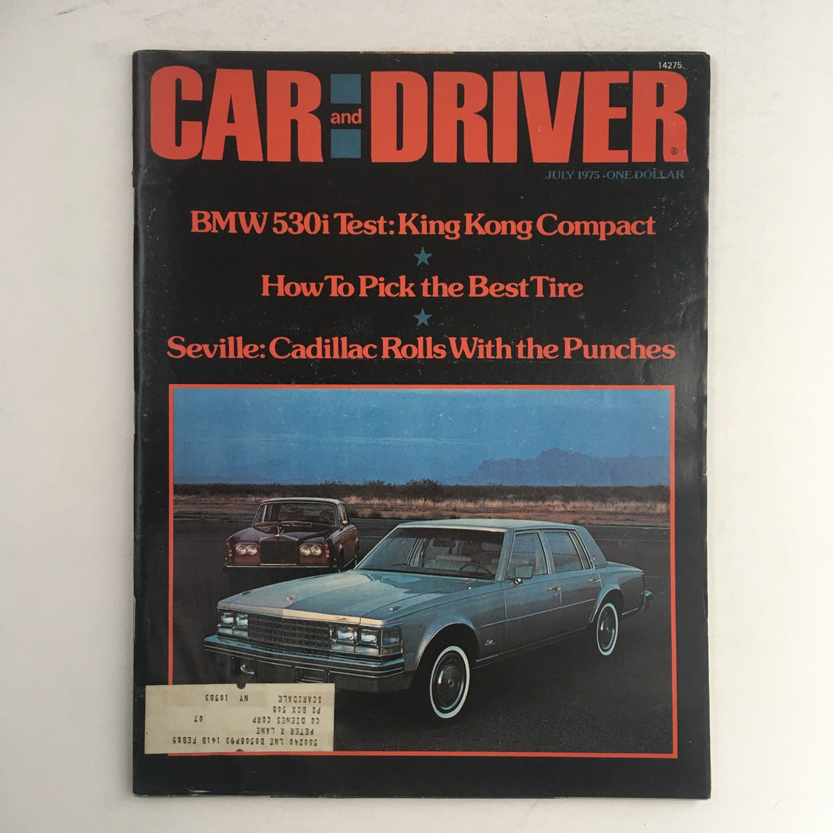 Cover of the July 1975 issue of Car & Driver Magazine featuring a test of the BMW 530i and a spotlight on the Cadillac Seville. The vibrant layout showcases cars in a scenic background, with headlines emphasizing key articles.