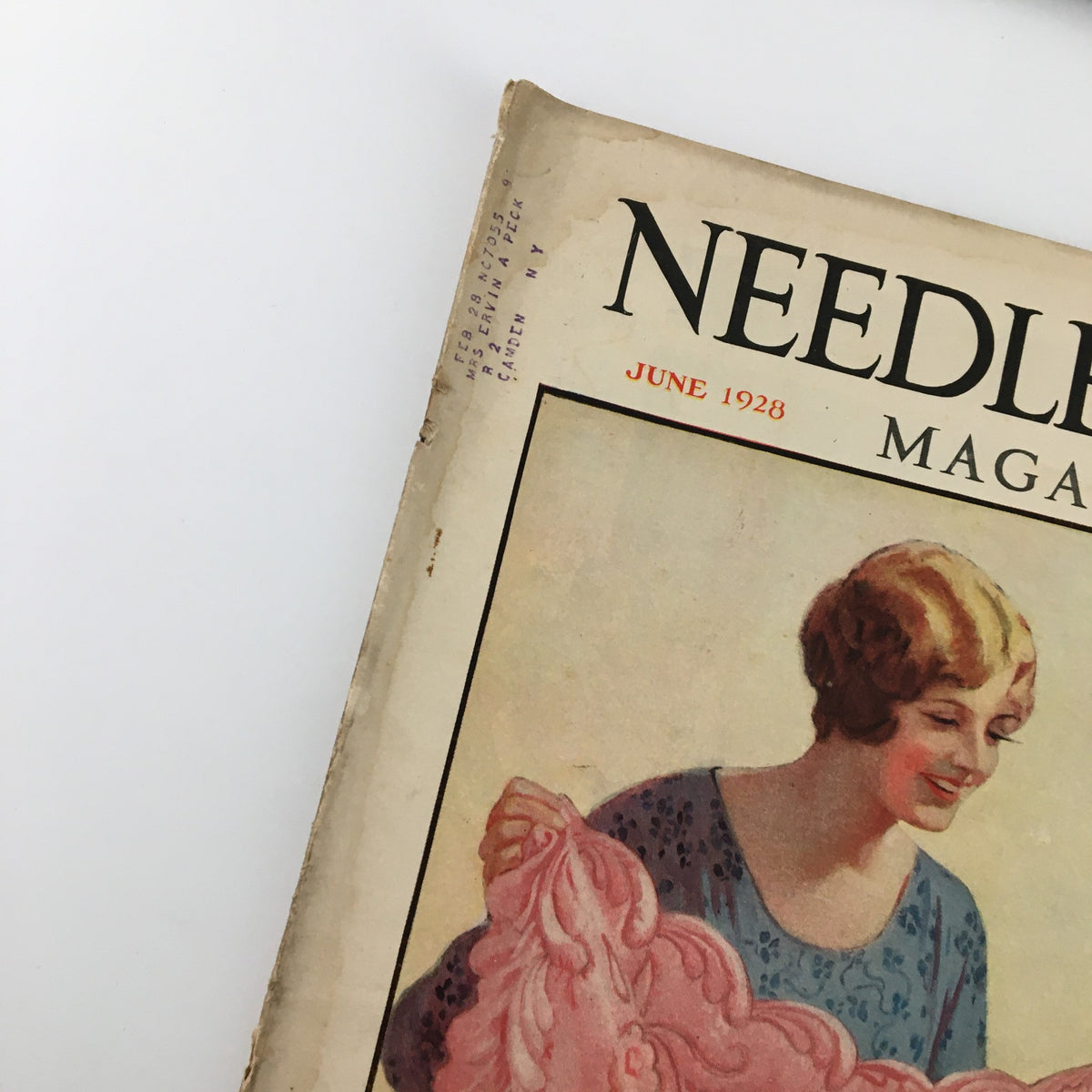 Close-up of the VTG Needlecraft Magazine June 1928 cover showing a smiling woman and decorative quilt.