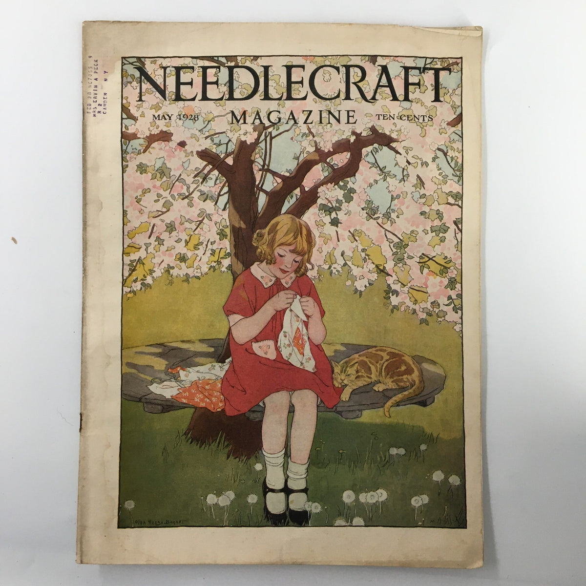 Cover of VTG Needlecraft Magazine May 1928 Vol. 19 No. 9 featuring a young girl sewing under a flowering tree, with a cat resting nearby.