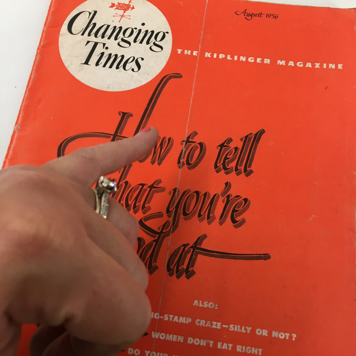 Close-up of the VTG Changing Times Magazine August 1956 cover with focus on the title 'How to Tell What You're Good At' and a finger pointing at the text.
