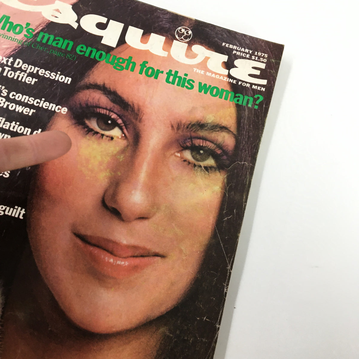 Close-up view of the cover of VTG Esquire Magazine February 1975, highlighting the title 'Who's Man Enough For This Woman?' and the iconic image of Cher.