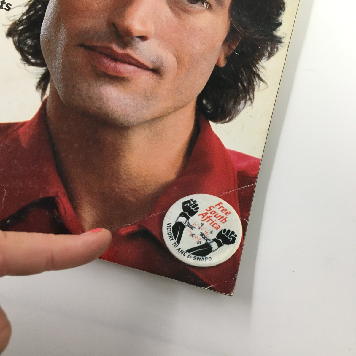 Close-up of a vintage Esquire Magazine from November 1985, featuring a man with prominent hair and a 'Free South Africa' button on his shirt, highlighting the cultural and political sentiments of the era.