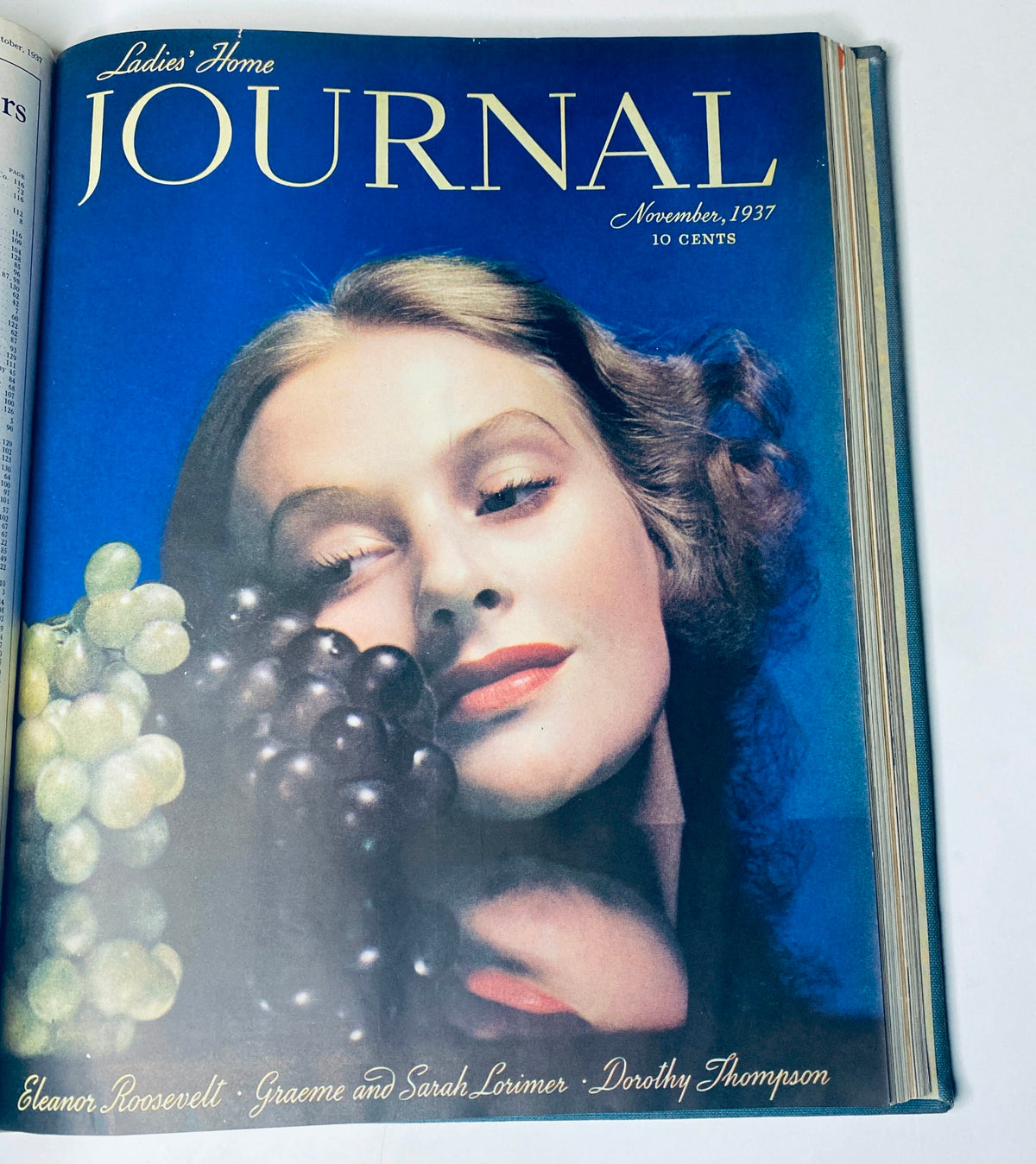 Cover of Ladies' Home Journal for November 1937 displaying a woman with a serene expression surrounded by grapes, capturing the vintage beauty and charm of the era.
