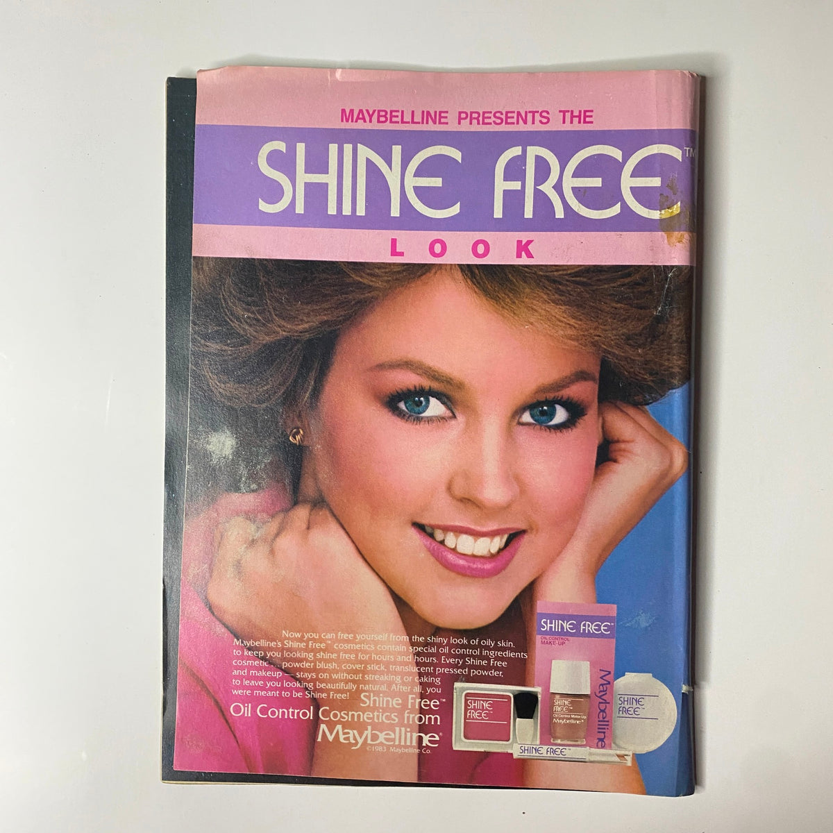 Cover of a Maybelline advertisement showcasing the Shine Free Look with a model demonstrating cosmetic products, from the March 1984 issue of Tiger Beat Magazine.