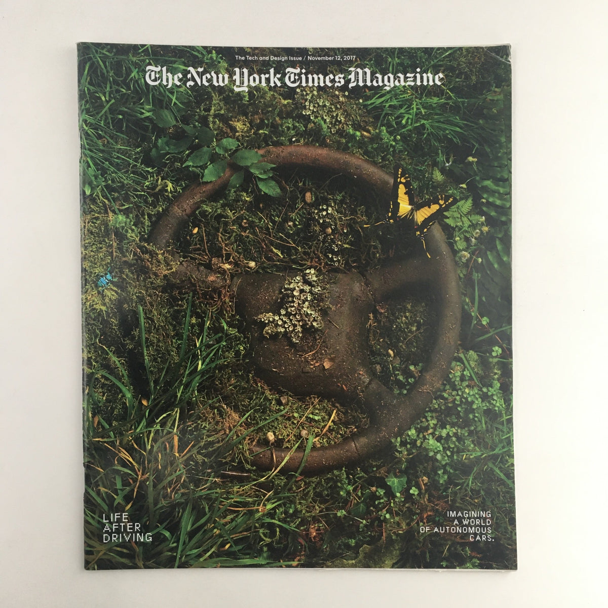 Cover of The New York Times Magazine from November 12, 2017, featuring the title 'Life After Driving'. The image showcases an old car steering wheel overgrown with grass and weeds, symbolizing changing transportation trends.